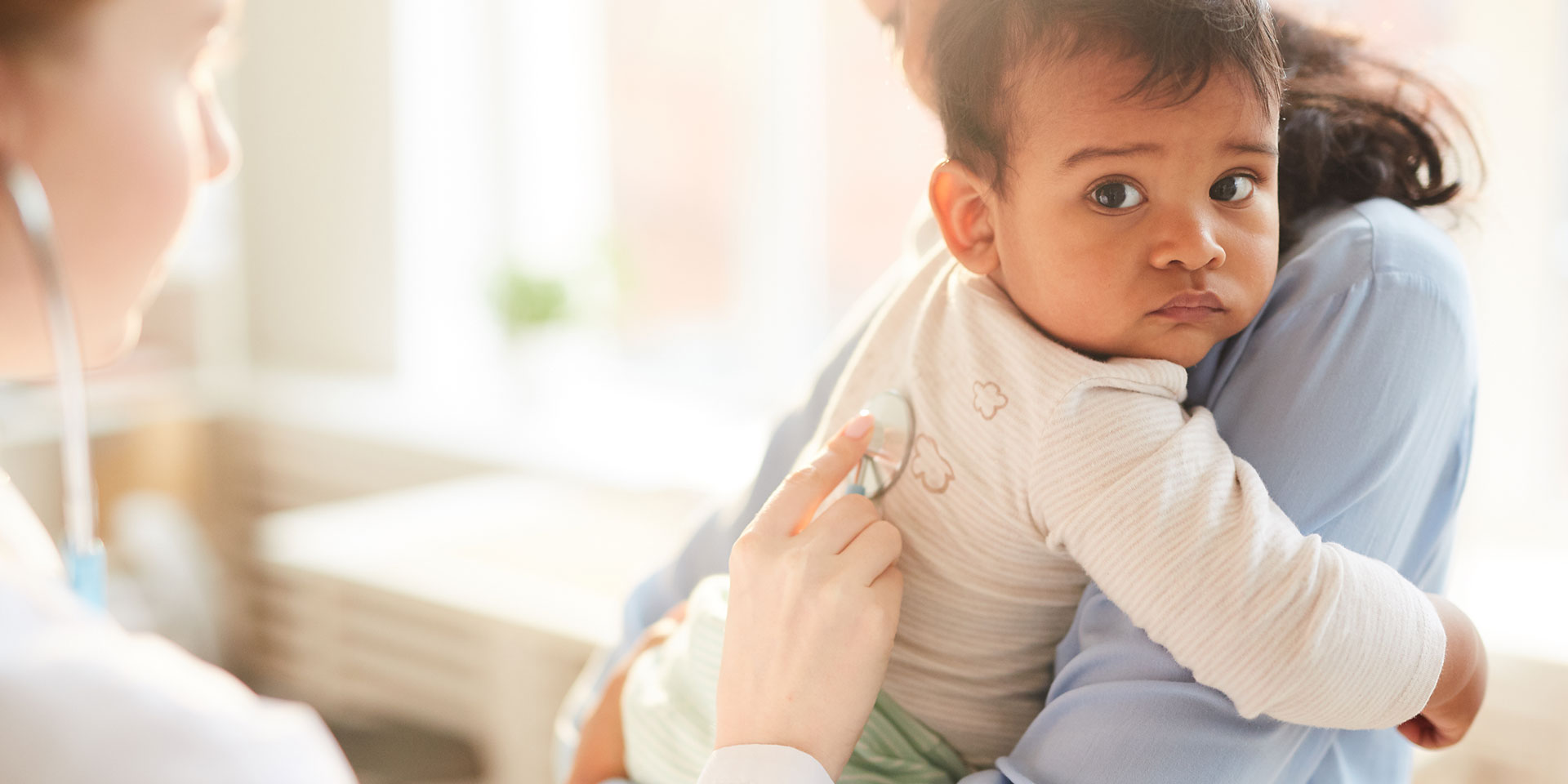 image of infant with doctor and parent